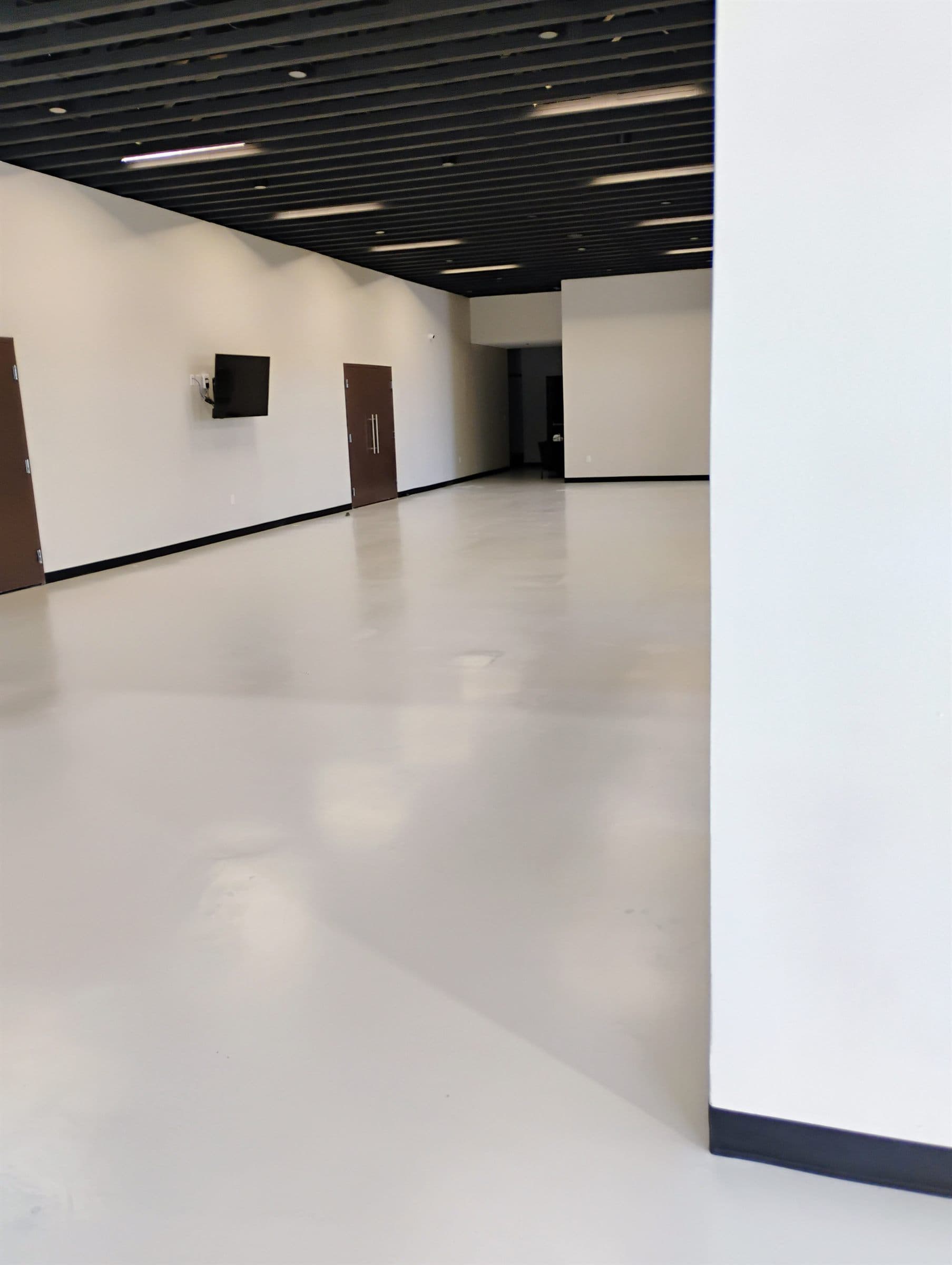 Light grey coated concrete floor running through an open commercial interior.