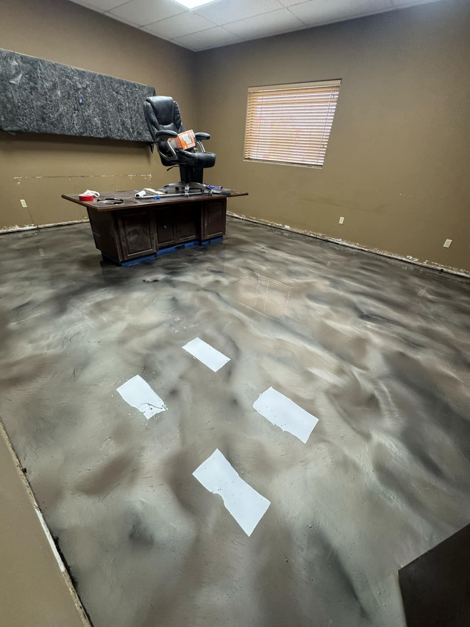 Pewter and charcoal metallic epoxy floor, hand-worked into a marbled pattern across a finished office.